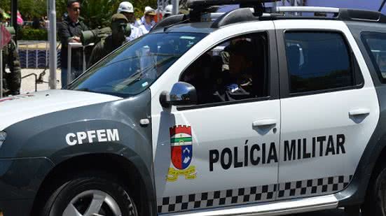 Após a série de agressões, o suspeito é colocado no porta-malas de uma das viaturas - Reprodução/Internet