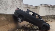 Carro ficou inclinado perigosamente sobre o muro - Foto: Reprodução