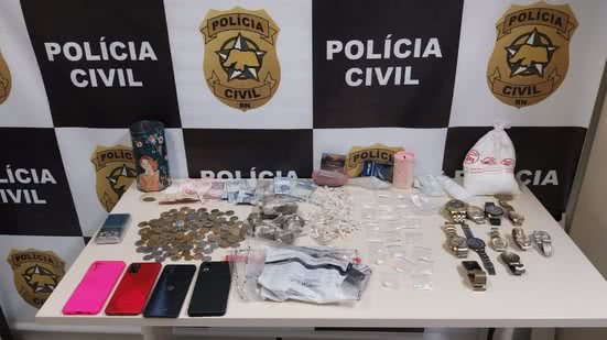 Entre os materiais apreendidos estão: uma arma de fogo caseira, 155 pedras de crack, uma pedra maior da mesma droga, 11 porções grandes de maconha e 23 porções de pó semelhante à cocaína - Divulgação/Polícia Civil do RN