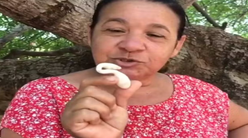 Givaneide Barbosa, filha da agricultora Edite, mostra o ovo que nasceu com um formato diferente no RN — Foto: Reprodução/Inter TV Cabugi