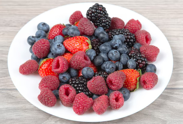 Frutas vermelhas sortidas, como mirtilo, amora e morango.